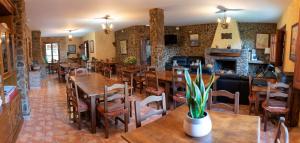 圭哈尔谢拉Hotel Rural Fuente La Teja的一间带桌椅和壁炉的餐厅