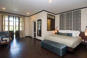 琅勃拉邦阿普萨拉萊夫卓伊特酒店的一间卧室配有一张特大号床和一张沙发