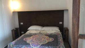 雷卡纳蒂Il Viandante的一间卧室配有一张带大型木制床头板的床