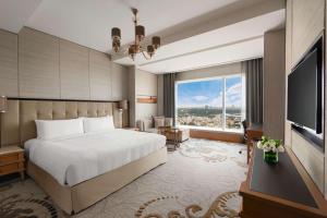 班加罗尔班加罗尔香格里拉酒店的酒店客房设有一张床和一个大窗户