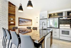 斯托纳姆52 Chemin de la Perdrix的厨房配有大型木桌和椅子