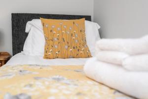 CockfieldMerlin House的一张带棕色枕头和白色床单的床