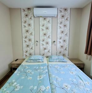 索普隆Székely Ház的一间小卧室,配有两张带蓝色床单的床