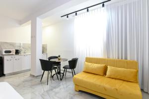 提比里亚Lake Mansion Boutique Apartments的客厅配有黄色的沙发和桌子