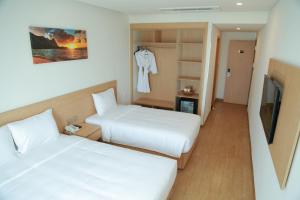 岘港Gold Boutique Hotel Danang的一间酒店客房,设有两张床和电视