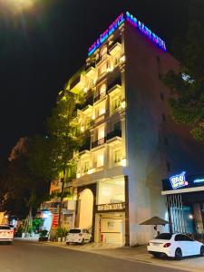 土龙木市SAO BĂNG HOTEL的酒店大楼前面设有停车场