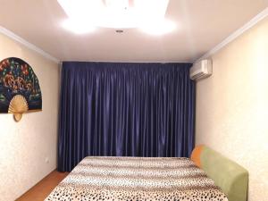 第聂伯罗пр. Александра Поля 100, центральная часть города的一间卧室配有床和蓝色窗帘