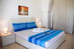 卡斯特里尼亚诺德尔卡波Complesso Centopietre by TerraSalento的一间卧室配有蓝色和白色床单