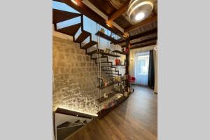 维泰博DOMUS TUSCIA APARTMENTS Via Estrema 2的一间设有砖墙和楼梯的客厅