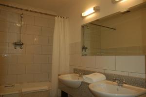 肯梅尔肯梅尔旅馆的浴室设有2个水槽、镜子和浴缸。