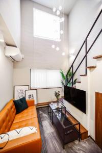 东京Ken's Place Azabudai的客厅配有橙色沙发和电视