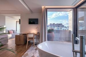 雅典Niche Hotel Athens的带浴缸、桌子和书桌的浴室