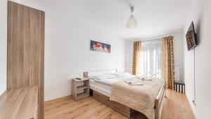 科沃布热格Apartamenty Sun & Snow Na Solnej的一间卧室配有一张床,铺有木地板
