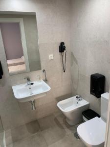 莫特里尔海星酒店的一间带水槽和卫生间的浴室以及一部电话