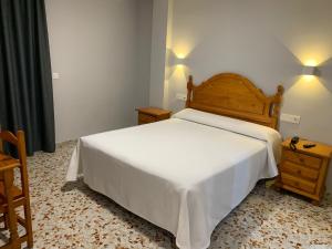 莫特里尔海星酒店的卧室配有白色的床和木制床头板