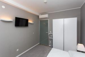 杜布罗夫尼克兹奥姆兹奥姆公寓的卧室配有一张床,墙上配有电视。