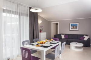 杜布罗夫尼克兹奥姆兹奥姆公寓的客厅配有白色桌子和紫色椅子