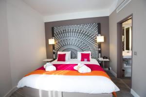 南特南特中心格兰德美居酒店的一间卧室配有一张带红色枕头的大床