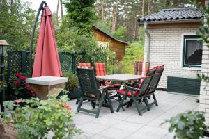 科尔平塞Ferienhaus Matthies的庭院配有桌椅和遮阳伞。