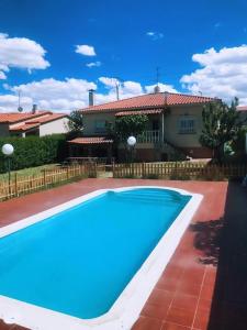 下卡尔瓦拉萨Chalet piscina privada Salamanca的房子前面的蓝色游泳池