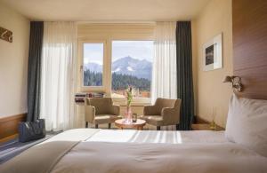 莱克斯西格妮娜酒店的一间卧室配有一张床、两把椅子和一个窗户