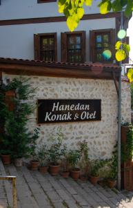 番红花城Hanedan Konak Hotel的植物建筑的一侧的标志