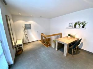 布吕根4*+ Maisonette-Apartment的一间带木桌和椅子的用餐室