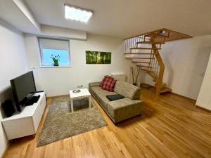 布吕根4*+ Maisonette-Apartment的带沙发和楼梯的客厅