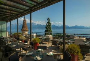 洛桑萨沃伊皇家Spa酒店的一间带桌椅并享有水景的餐厅