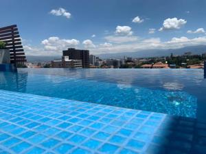 科恰班巴Depto de lujo en Smart Design的一个大游泳池,后面有一个城市