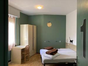 托斯科拉诺-马德尔诺Route77 hostel的绿墙客房内的两张床