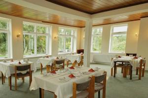 肯梅尔肯梅尔旅馆的一间设有白色桌椅和窗户的用餐室