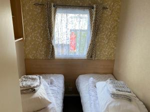 塔特舍尔3 bedroom 8 berth Standard Basic caravans with Hot Tub,Mountain Bikes的小型客房 - 带2张床和窗户