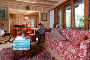 圣卡特琳娜瓦尔夫QC House - Chalet con Sauna的两个女人坐在客厅的沙发上