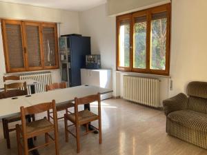 托斯科拉诺-马德尔诺Route77 hostel的厨房配有桌椅和冰箱。