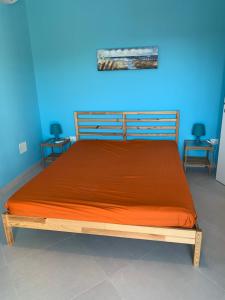 普尔萨诺Appartamento Cielo的一间卧室配有一张带橙色床罩的床