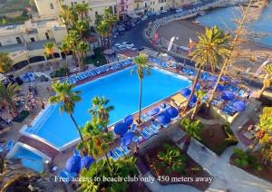 圣朱利安斯Antoniel Suites的享有棕榈树度假村泳池的顶部景致