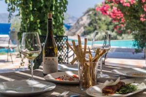 库卡里阿尔莫尼亚海湾酒店的一张桌子,上面放着一瓶葡萄酒和两杯酒