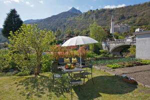 卡尼洛瑞维拉Casa Limoni的院子里的桌椅和雨伞