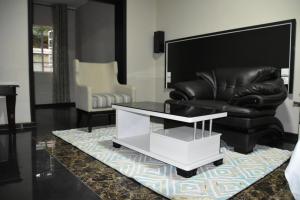 利隆圭Annavilla7 Lilongwe Aparthotel的客厅配有黑色真皮沙发和咖啡桌