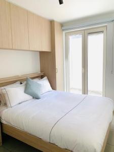 尼乌波特Even Aan Zee - Largo的卧室配有白色床和蓝色枕头
