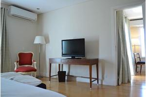 门多萨Hotel Finca Hermitage的一间卧室配有一张桌子,里面配有电视