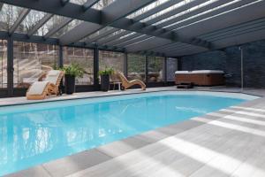斯帕奥尔恩别墅住宿加早餐旅馆的一座带玻璃天花板的别墅内的游泳池