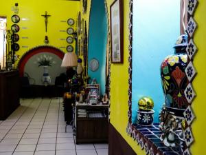 瓜达拉哈拉Hostel Casa Zalaoui的一间黄色墙壁的房间,在柜台上有一个花瓶