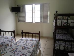 大普拉亚Pousada Difusão Cultural的一间卧室设有两张双层床和一扇窗户。