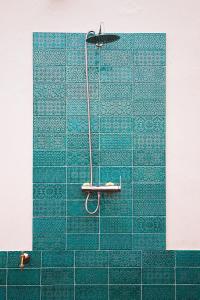 加的斯Ático Terraza Torre Tavira的浴室设有蓝色瓷砖墙和淋浴。