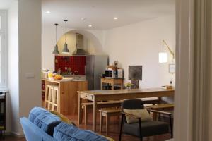 蓬塔德尔加达A Bica Hostel的厨房以及带桌椅的起居室。