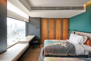 香港the Arca的一间卧室配有一张床、一张书桌和一个窗户。