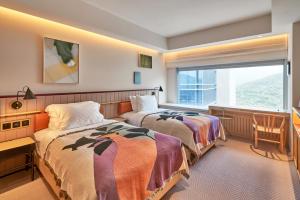 香港the Arca的酒店客房设有两张床和窗户。