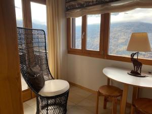 韦松纳Eanta SUNNY & MOUNTAIN chalet 10 pers by Alpvision Résidences的一间带椅子和一张桌子及窗户的房间